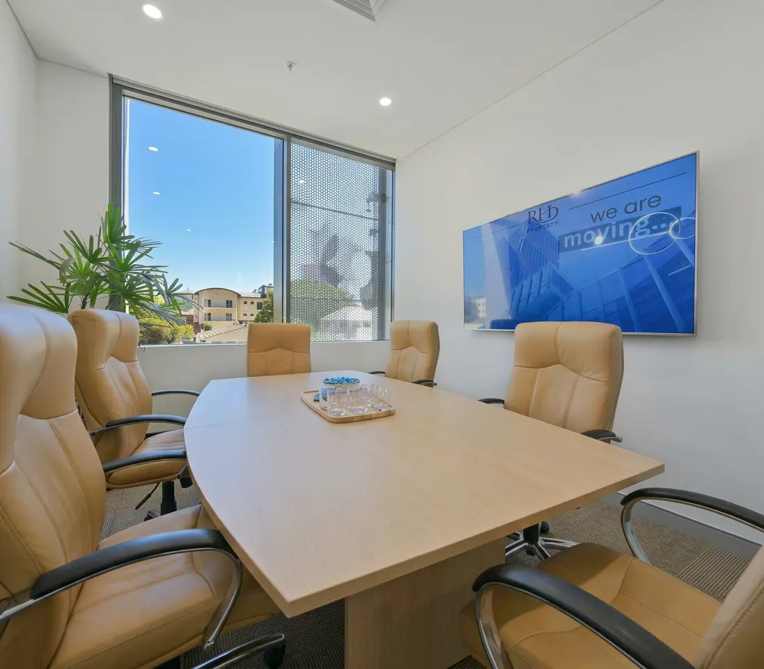 Modern office meeting room with large window and leather chairs, part of the Home property gallery.